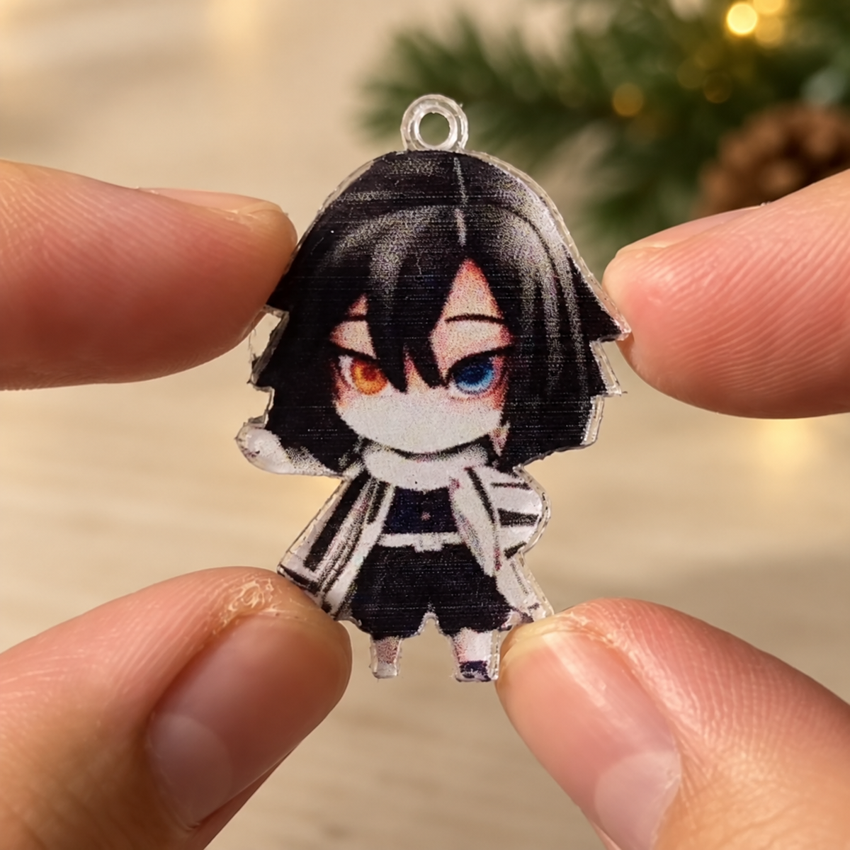 Recreated close-up from seller footage showing the small, thin printed character charm held between fingers